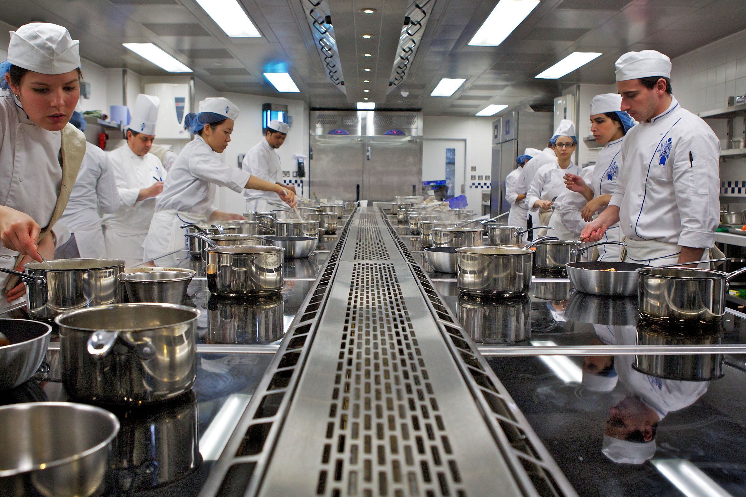 Well-equipped culinary classroom with clean preparation surfaces, cooking utensils, and ingredients ready for a hands-on lesson
